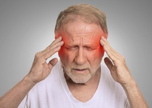 man with migraine rubbing his head with red inflamed areas on temples